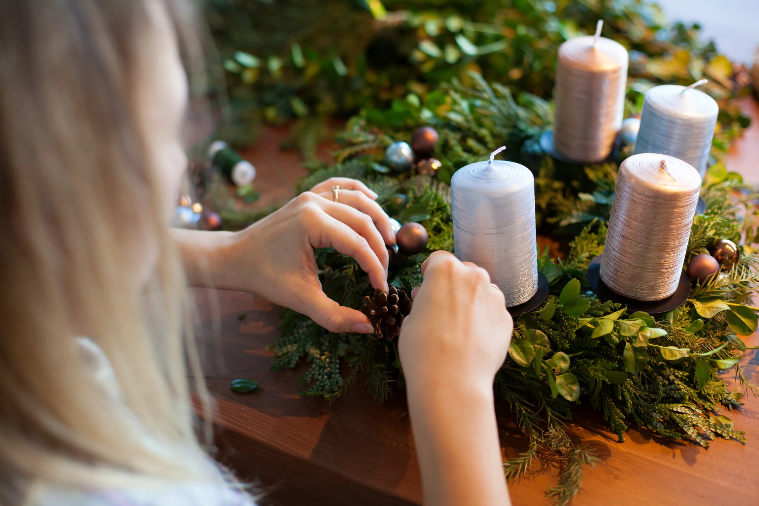 Une femme confectionne une couronne de l'Avent