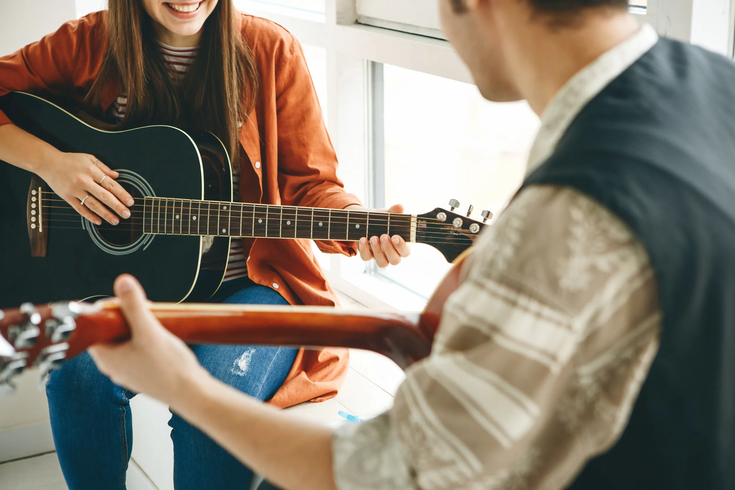 Une femme chez son professeur de guitare pendant un cours